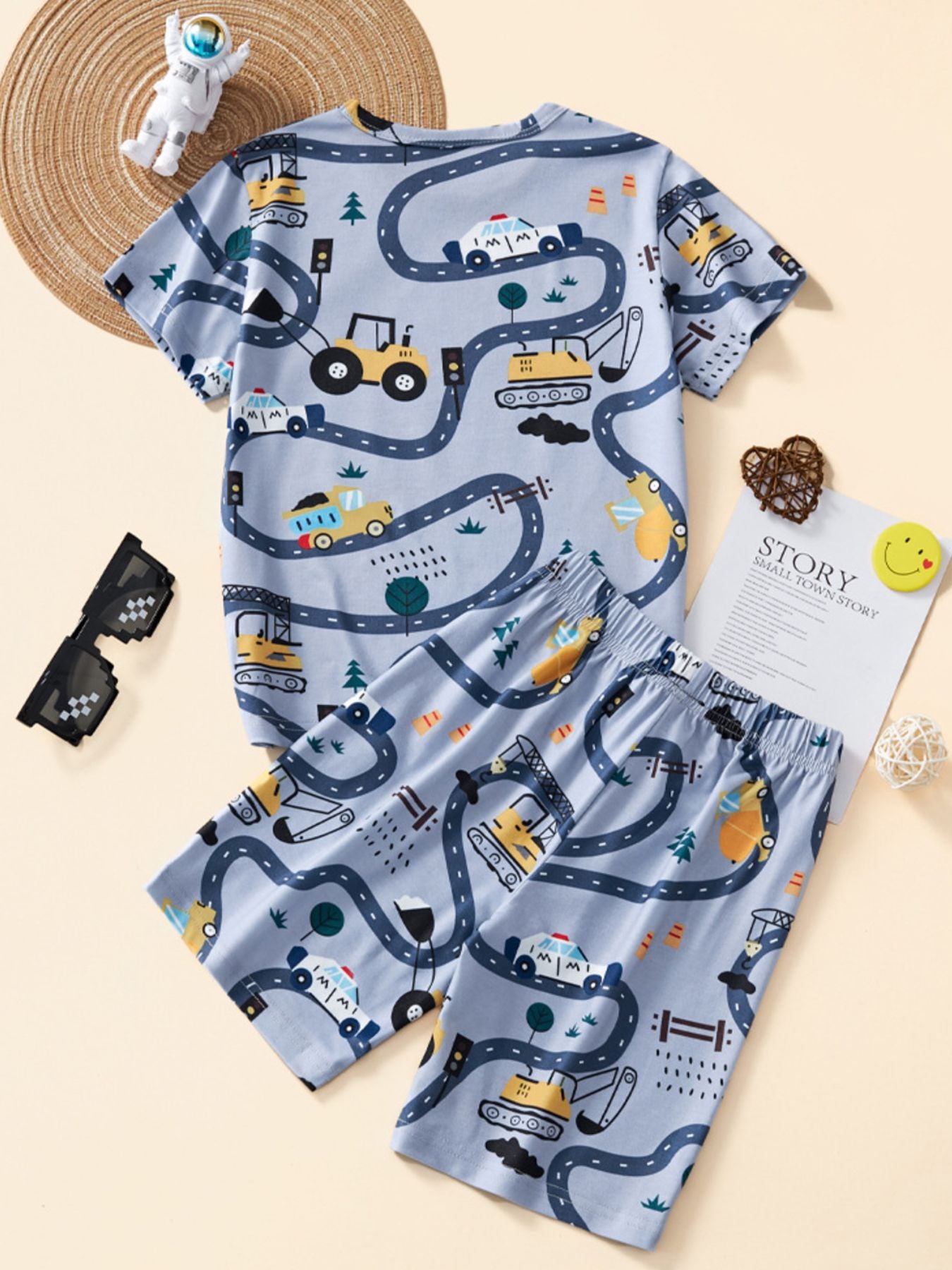 Light blue construction vehicle print toddler pajama set with short sleeves and shorts.