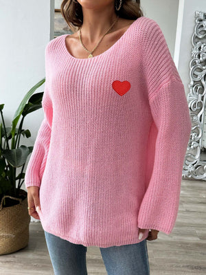 Pink slouchy boatneck knit sweater with embroidered red heart detail.