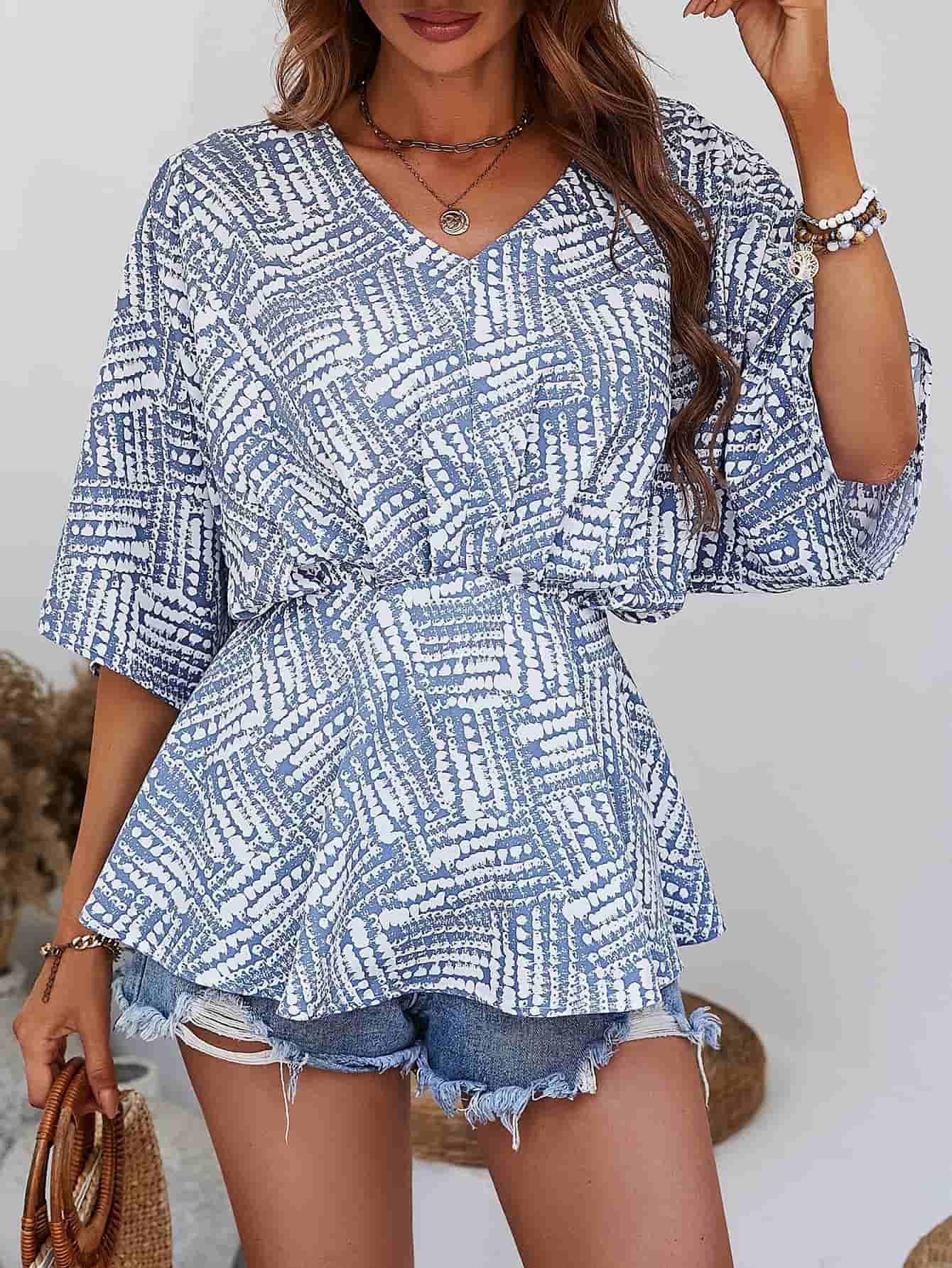 Light blue abstract print cinched waist blouse with V-neck and short sleeves.