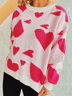 Heart motif knit sweater in hot pink and white acrylic with crew neck.
