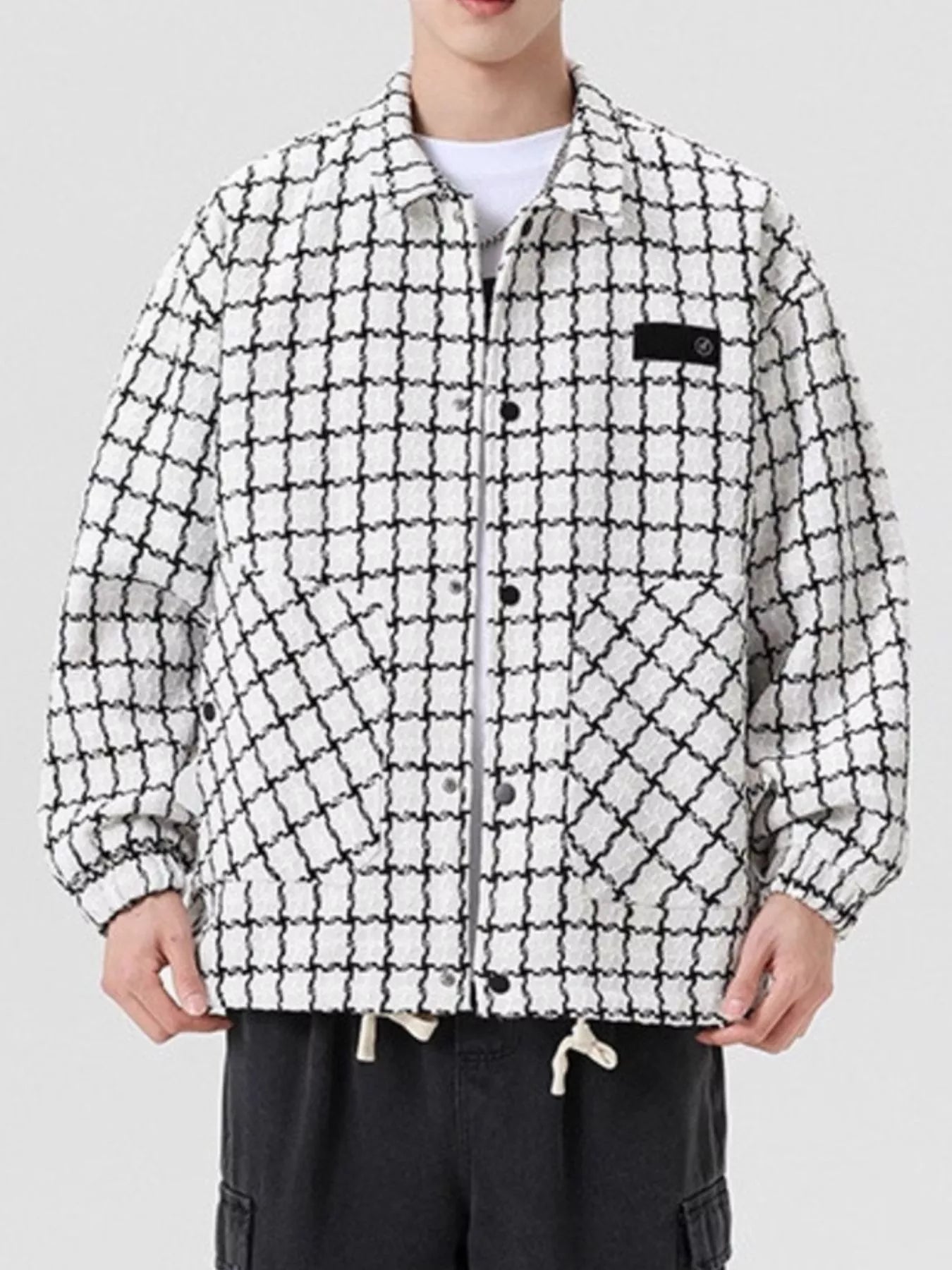 Oversized white plaid button-up jacket with black grid pattern and chest pocket detail.