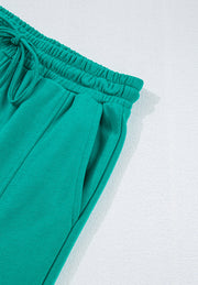 Turquoise lounge pants with drawstring waist and cargo pockets.