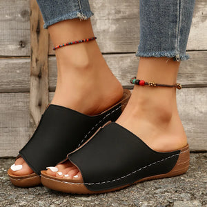 Black wedge mules with stitched edge detail and open toe.