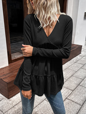 Black waffle knit peplum top with V-neck and long sleeves.