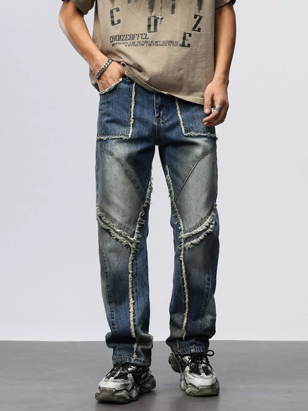 Men's blue denim wide leg jeans with frayed hem details and distressed accents.