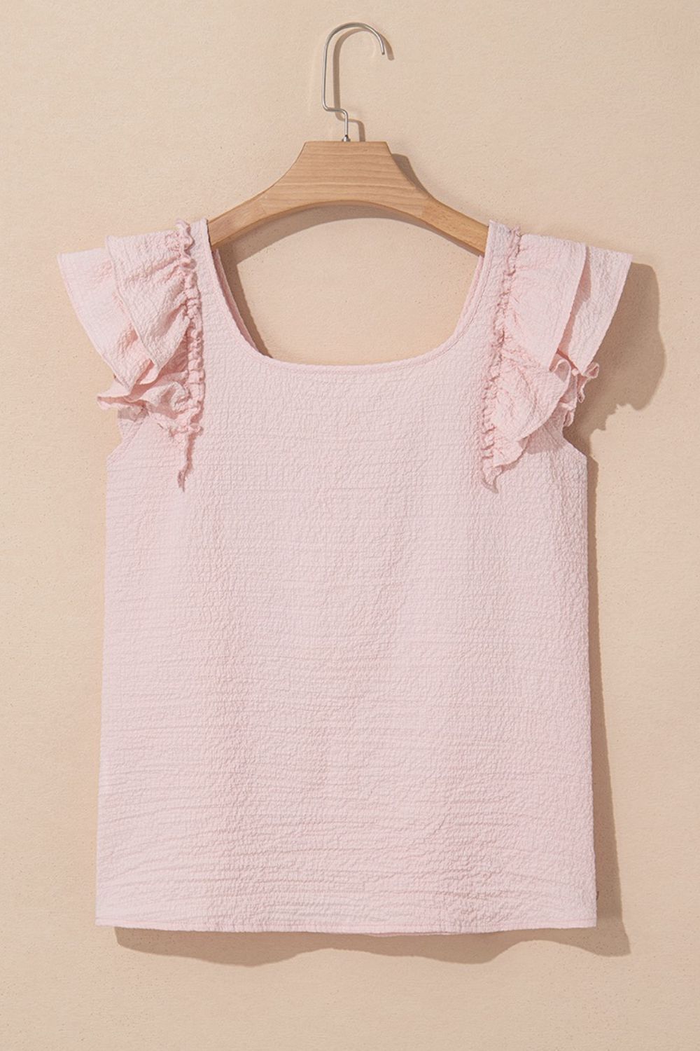 Blush pink textured blouse with square neck and ruffle cap sleeves.