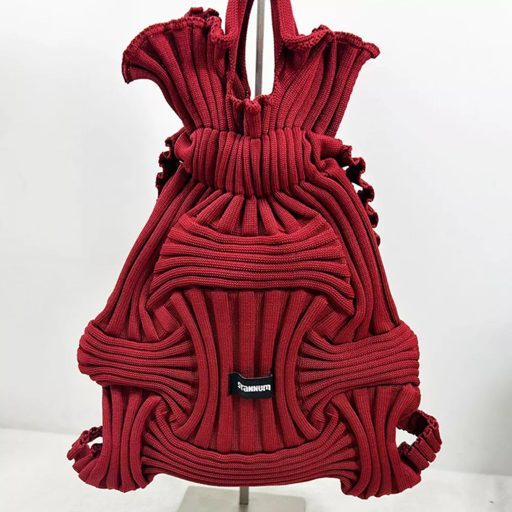 Textured knit medium backpack in burgundy with drawstring closure and unique ribbed pattern.