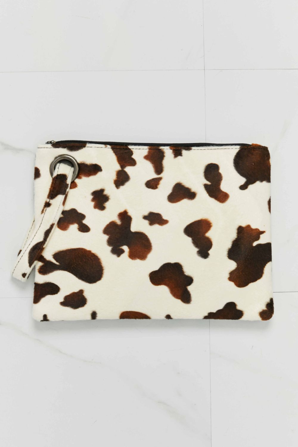 Brown and cream cowhide print clutch bag with wristlet strap