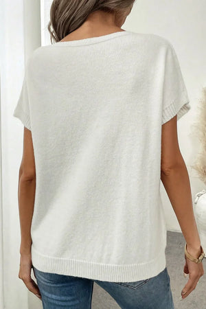 White knit tunic t-shirt with short sleeves and a ribbed hem, featuring a subtle bow motif detail on the front.