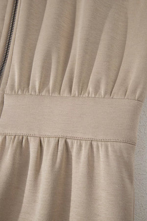 Chic collared zip front romper in beige with ruched detailing and a cinched waist.