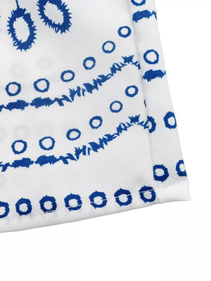 Bohemian maxi skirt with blue floral embroidery on white fabric.