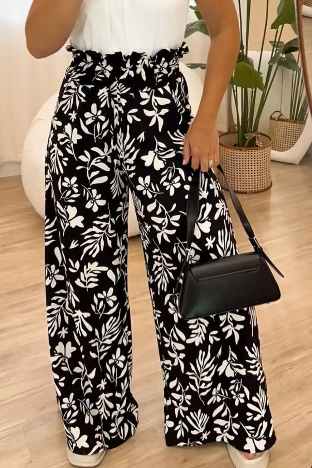 Black botanical ruffle waist palazzo trousers with a wide leg.