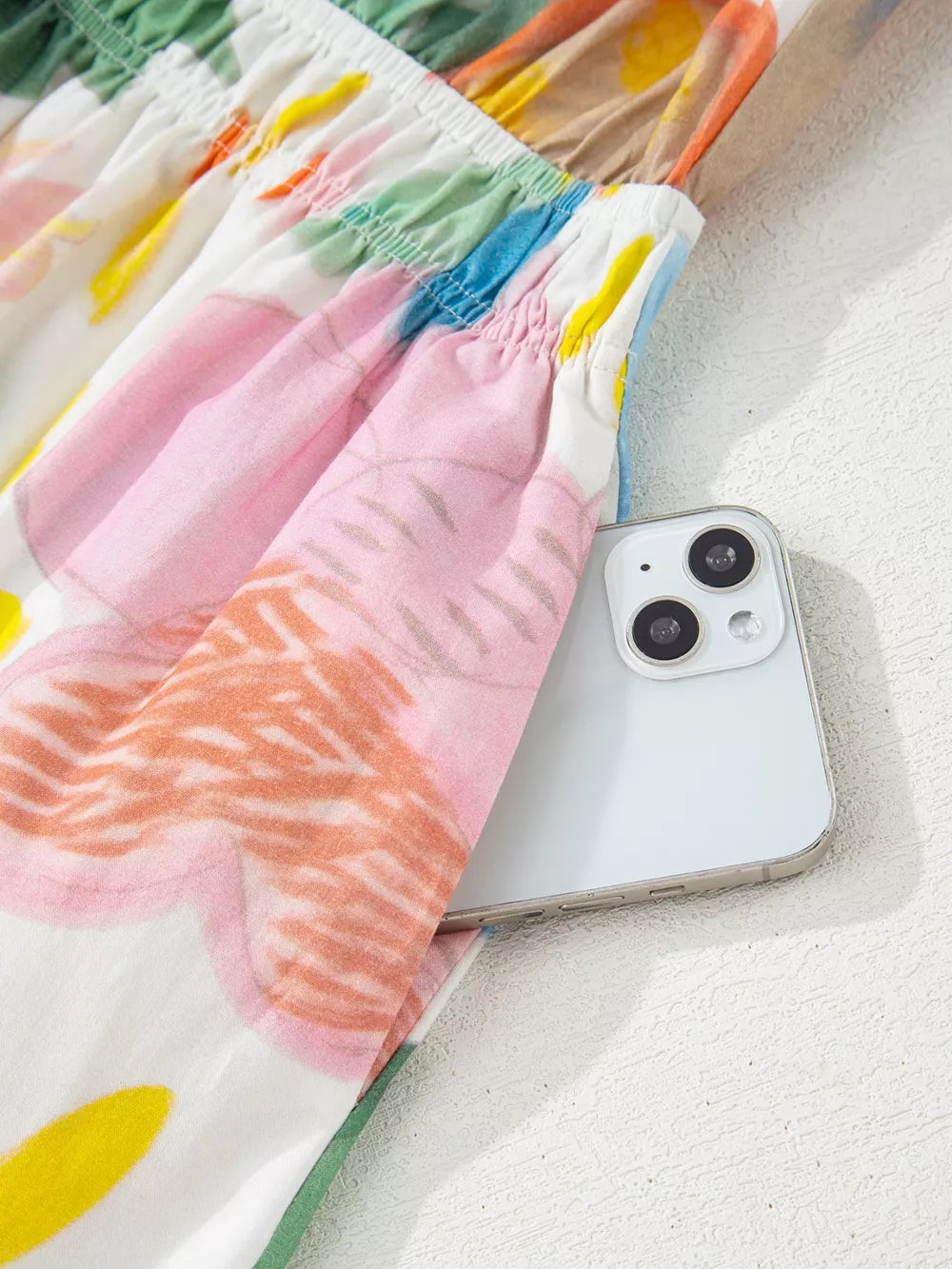 Midi dress with whimsical floral doodle print, 3/4 sleeves, and side pocket holding a phone.