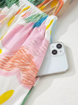 Midi dress with whimsical floral doodle print, 3/4 sleeves, and side pocket holding a phone.