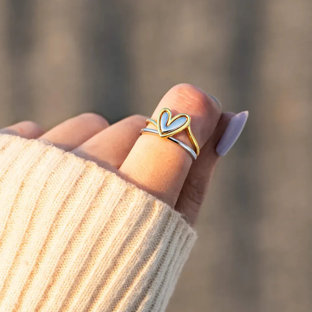 Two-tone gold and silver ring with a heart outline detail.
