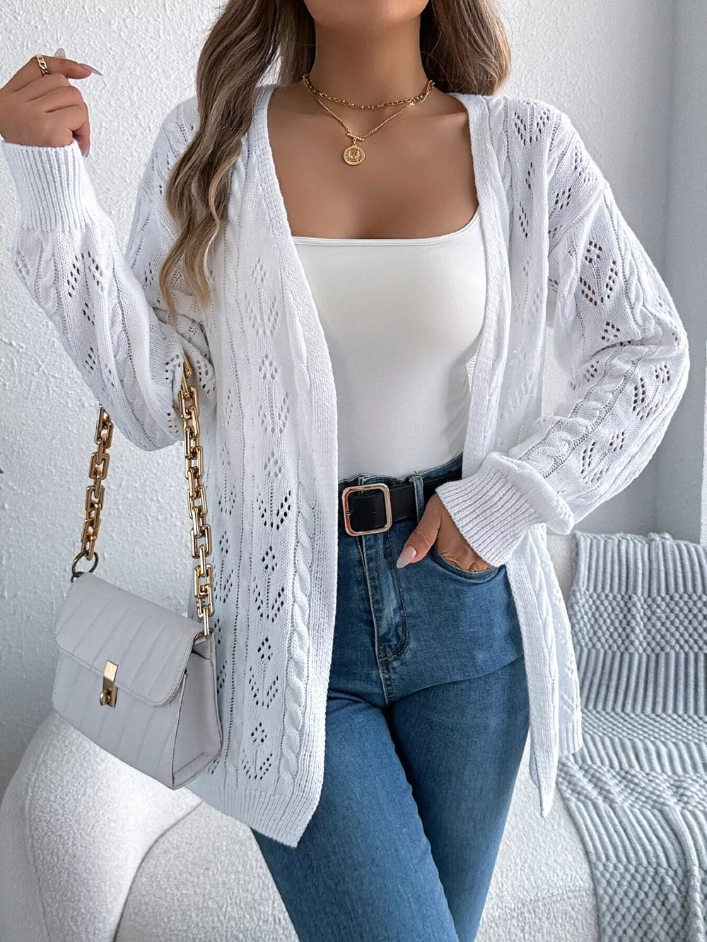 White openwork cable knit long sleeve cardigan with intricate diamond pattern.