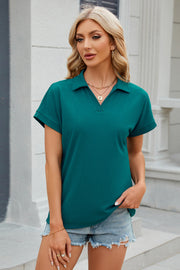 Teal textured polo top with cuffed short sleeves and a V-neck.