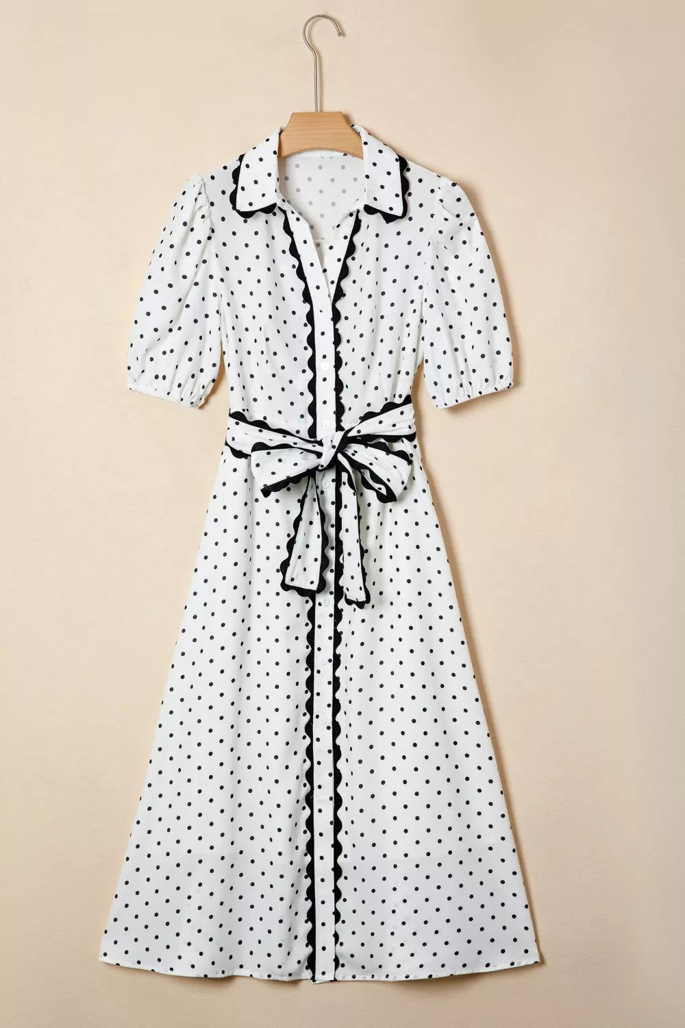 White polka dot midi dress with black trim and tie belt