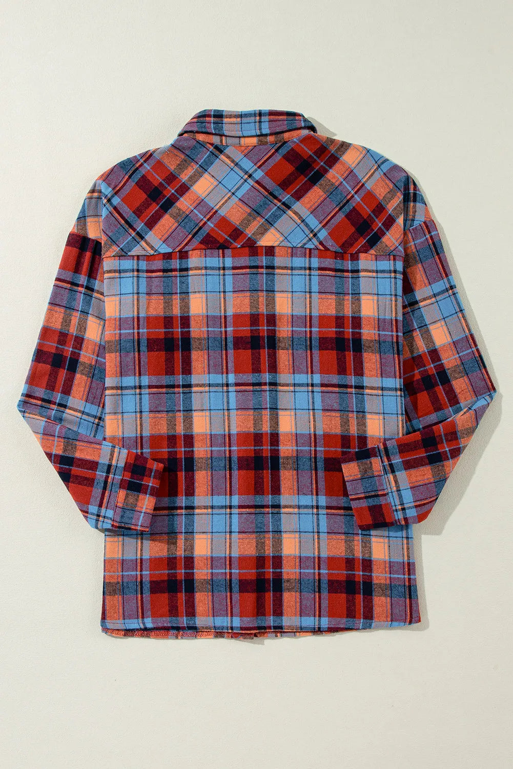 Oversized plaid shacket in orange and deep red with button-down collar and long sleeves.