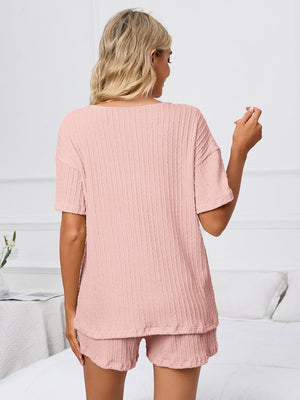 Blush pink ribbed knit pajama set with short sleeves and shorts.