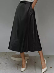 Black satin A-line midi skirt with pockets and a flowing silhouette.