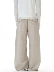Men's beige wide-leg cargo pants with button closure and flap pockets.
