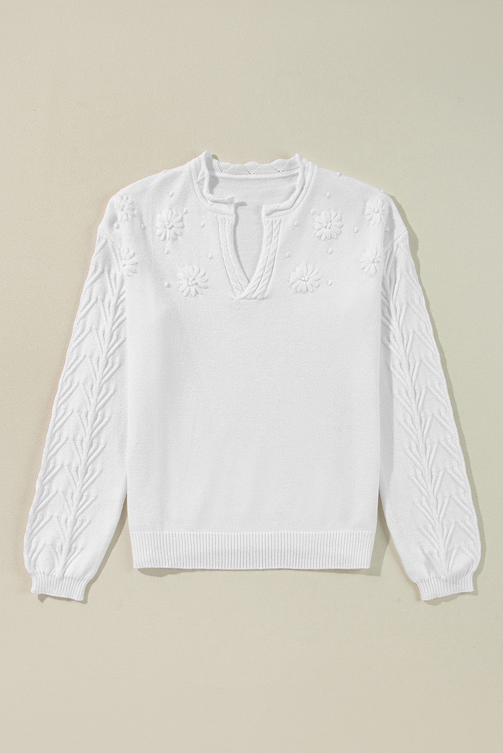 White embroidered floral knit sweater with notch neck and textured sleeves.