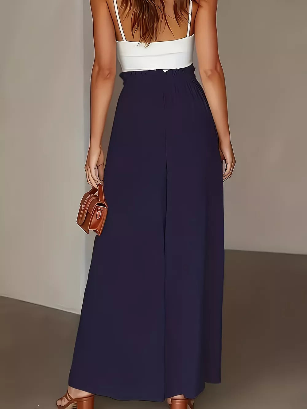 Dark blue wide-leg trousers with paperbag waist and a white camisole.