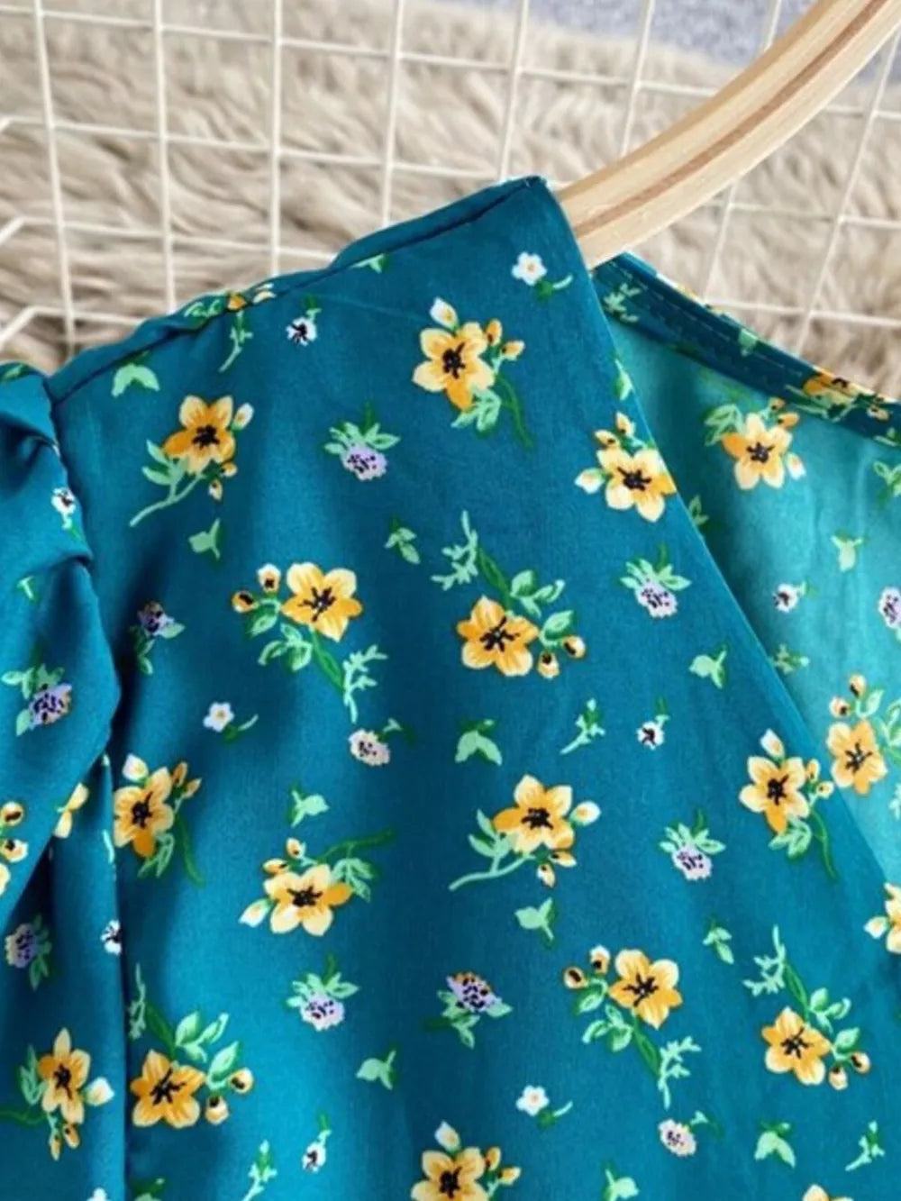 Teal floral midi dress with V-neck and short sleeves, featuring a yellow and purple floral print.