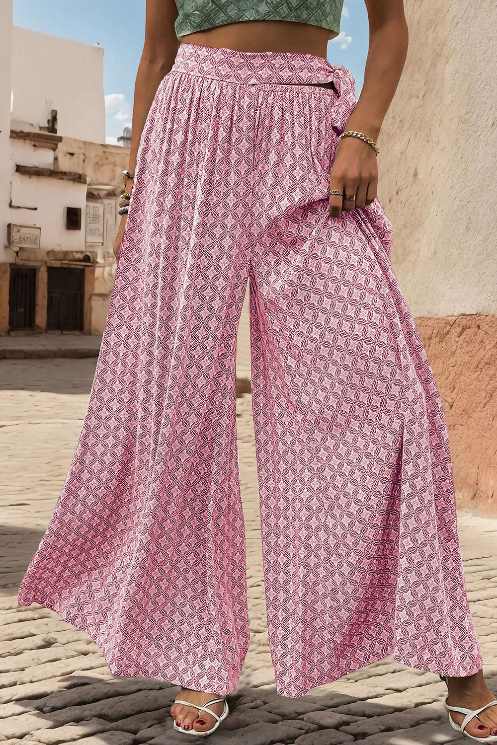 Pink geometric print wide-leg palazzo trousers with a tie waist detail.