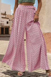 Pink geometric print wide-leg palazzo trousers with a tie waist detail.