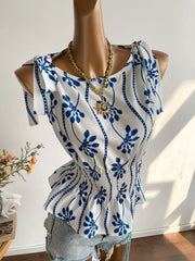 Botanical print smocked shoulder blouse with tie details and a boat neckline.