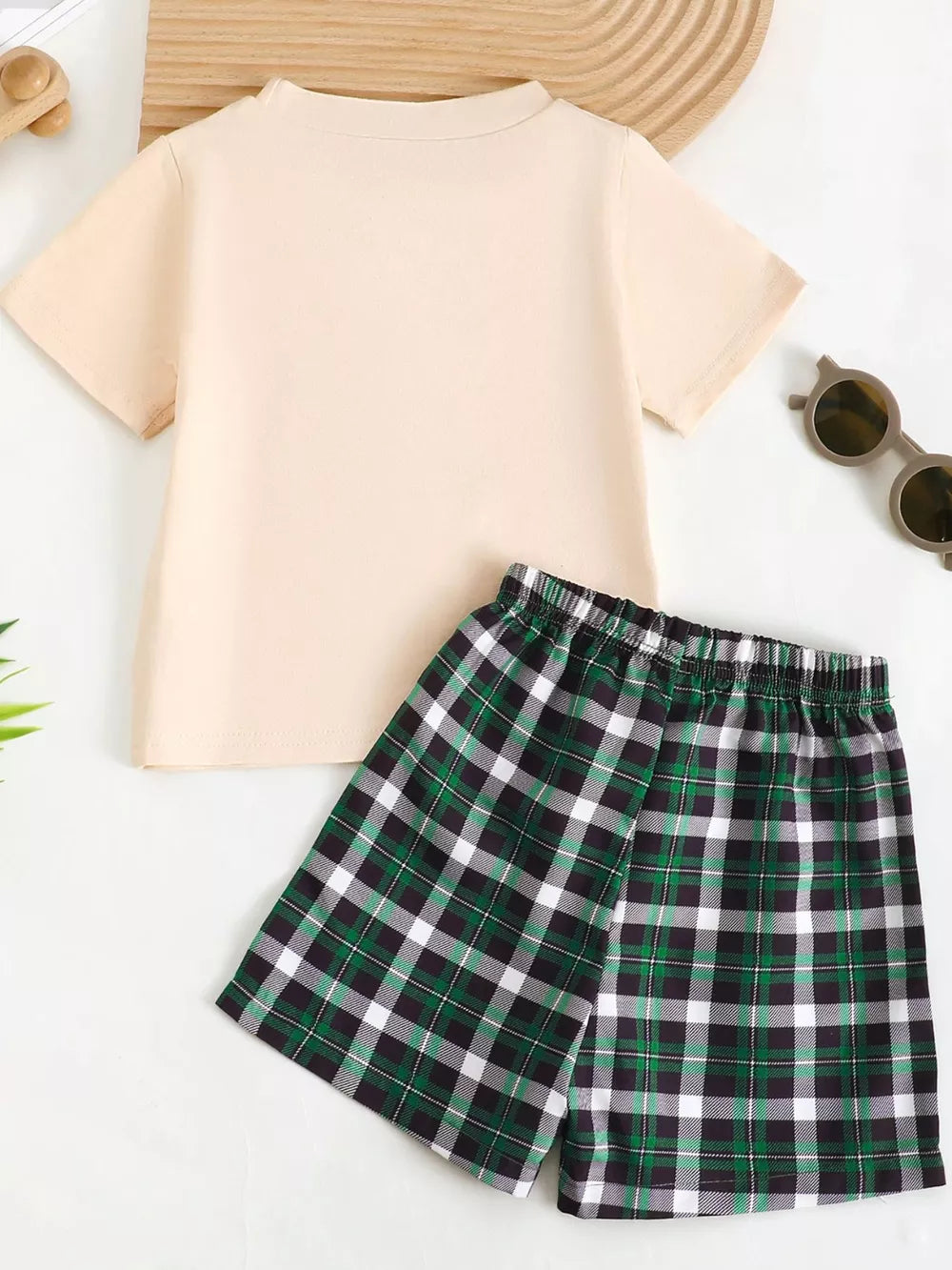 Baby set with a cream short sleeve tee and green plaid shorts.