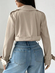 Beige cropped double-breasted trench coat with belt and adjustable cuffs.
