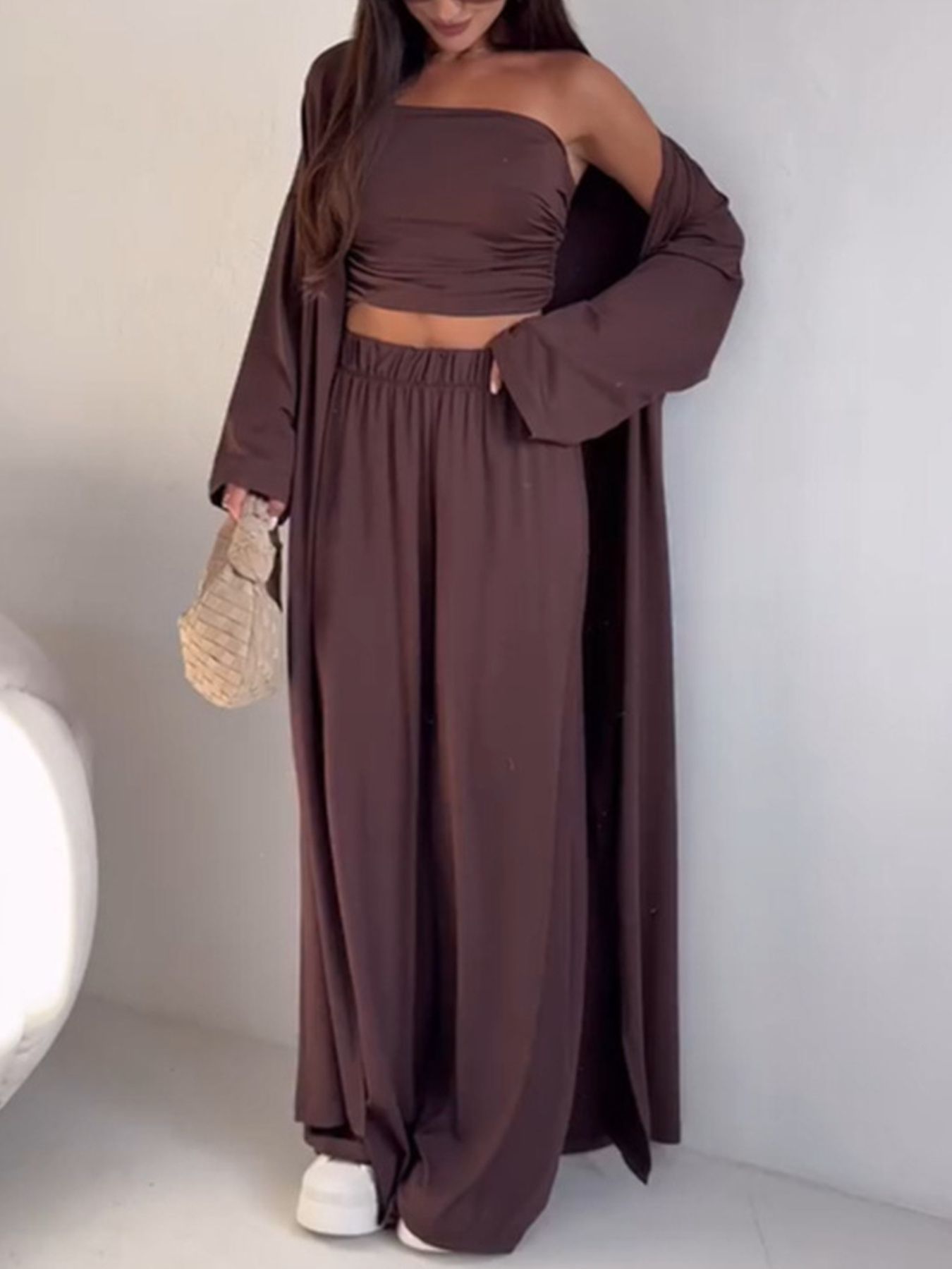 Dark brown ruched tube top, wide leg pants, and long open cardigan.