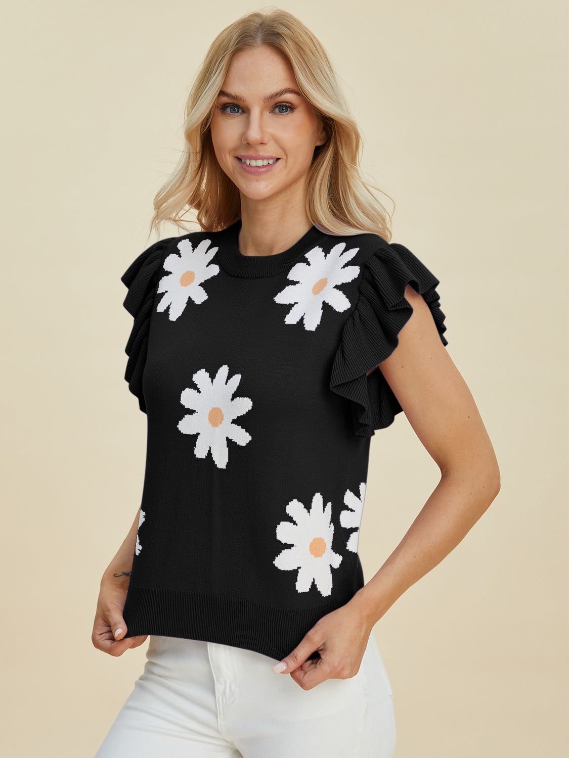Black knit blouse with white daisy print and ruffled short sleeves.