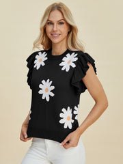 Black knit blouse with white daisy print and ruffled short sleeves.