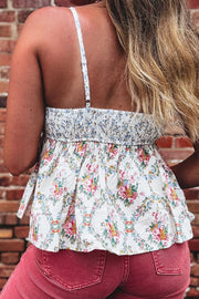 Floral babydoll tank top with smocked bodice and ruffled hem, polyester fabric.