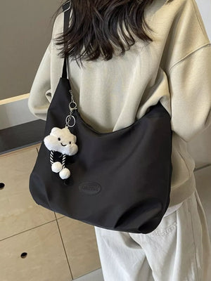 Black canvas shoulder bag with adjustable strap and cloud charm