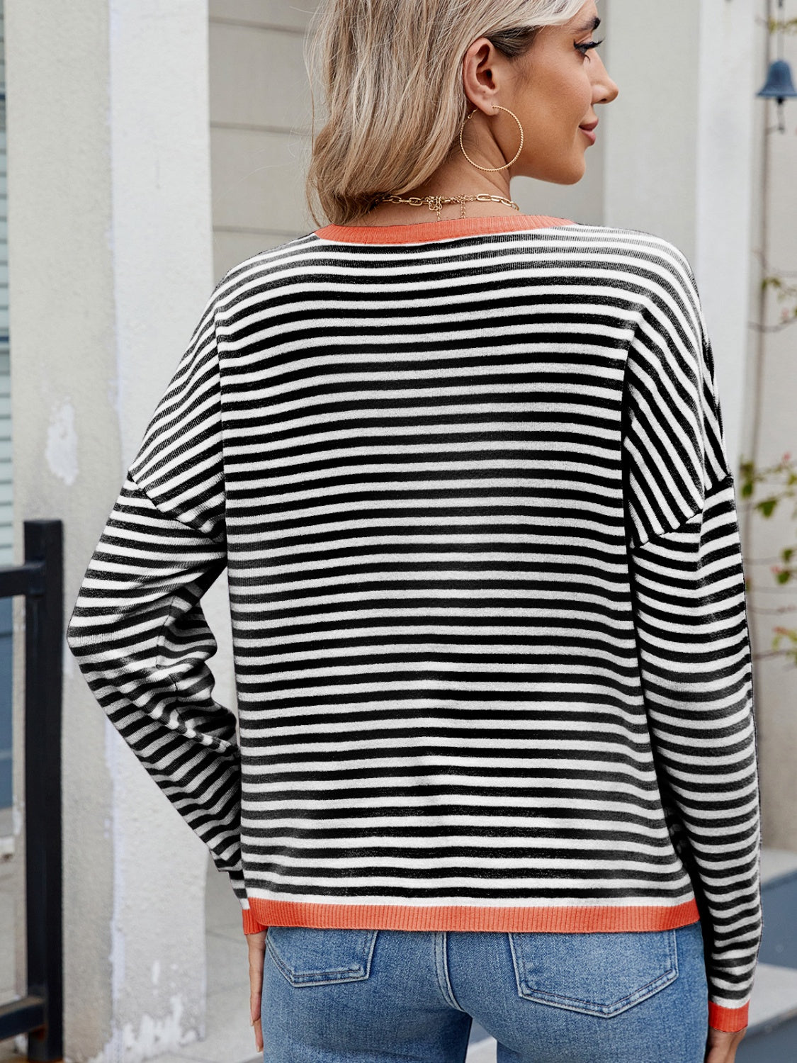 Black and white striped knit sweater with contrast trim and drop shoulder.