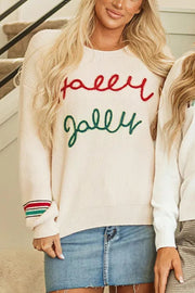 Ivory knit sweater with red "holly" and green "jolly" embroidery and striped cuffs.