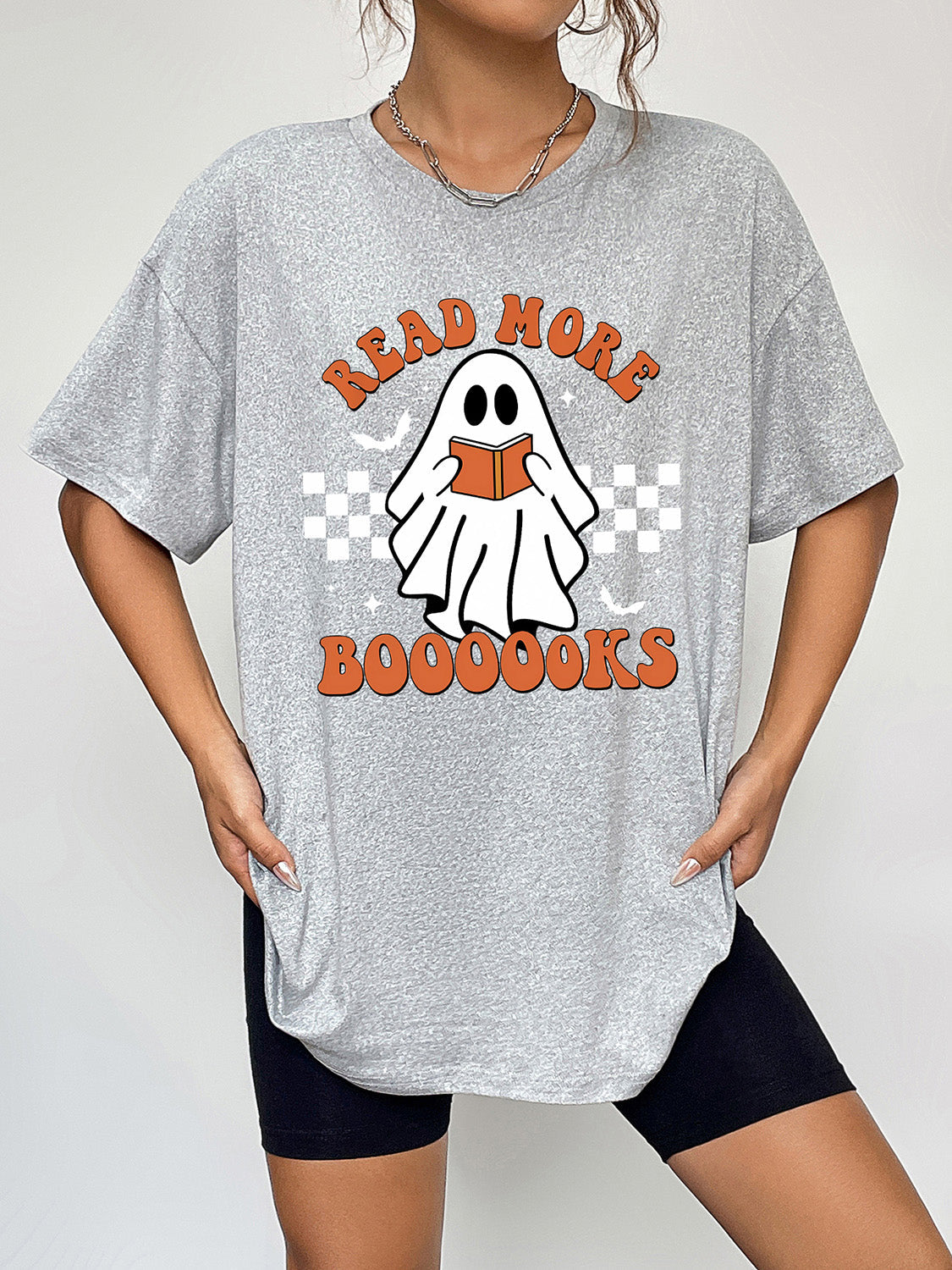 Grey graphic t-shirt with a ghost reading a book and "Read More Boooooooks" text
