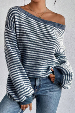 Blue off-shoulder knit pullover sweater with a gingham and stripe pattern.