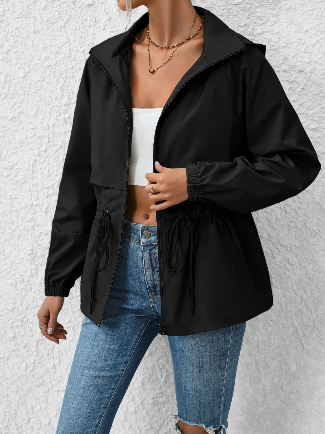 Black hooded utility jacket with cinched waist and drawstring details.