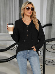 Black ribbed knit henley hoodie with buttons and drawstring hood, styled with jeans.