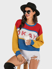 Colorblock knit sweater with "Okay" graphic, crew neck, and long sleeves.