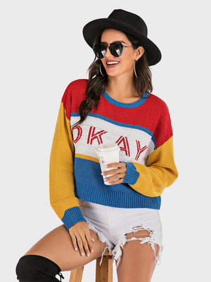 Colorblock knit sweater with "Okay" graphic, crew neck, and long sleeves.