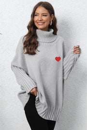 Light gray batwing knit turtleneck sweater with red heart embroidery and ribbed sleeves.