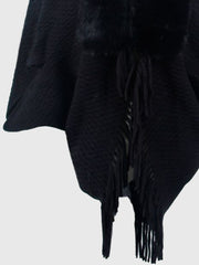 Black textured knit poncho with faux fur collar and fringe detail.