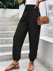Black relaxed-fit trousers with smocked waistline and cinched ankles